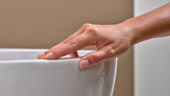 Hand streicht über WC mit Spezialglasur KeraTect®